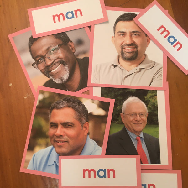 Collection of 4 pictures of a man, each one a different race, with a pink boarder around each photo.  Four labels with the word man are below each picture the word man is written with blue for vowels and red for consonants.